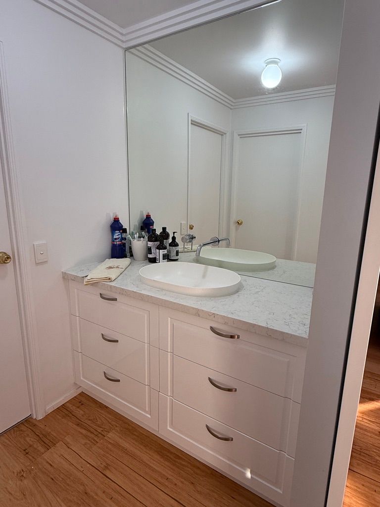 White Bathroom Vanity with Double Sinks, Mirror, Drawers, and Wood Floor — JPR Concepts in Burleigh Heads, QLD