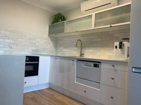 Modern White Kitchen with Built In Appliances, Tiled Backsplash, and Open Shelving — JPR Concepts in Burleigh Heads, QLD