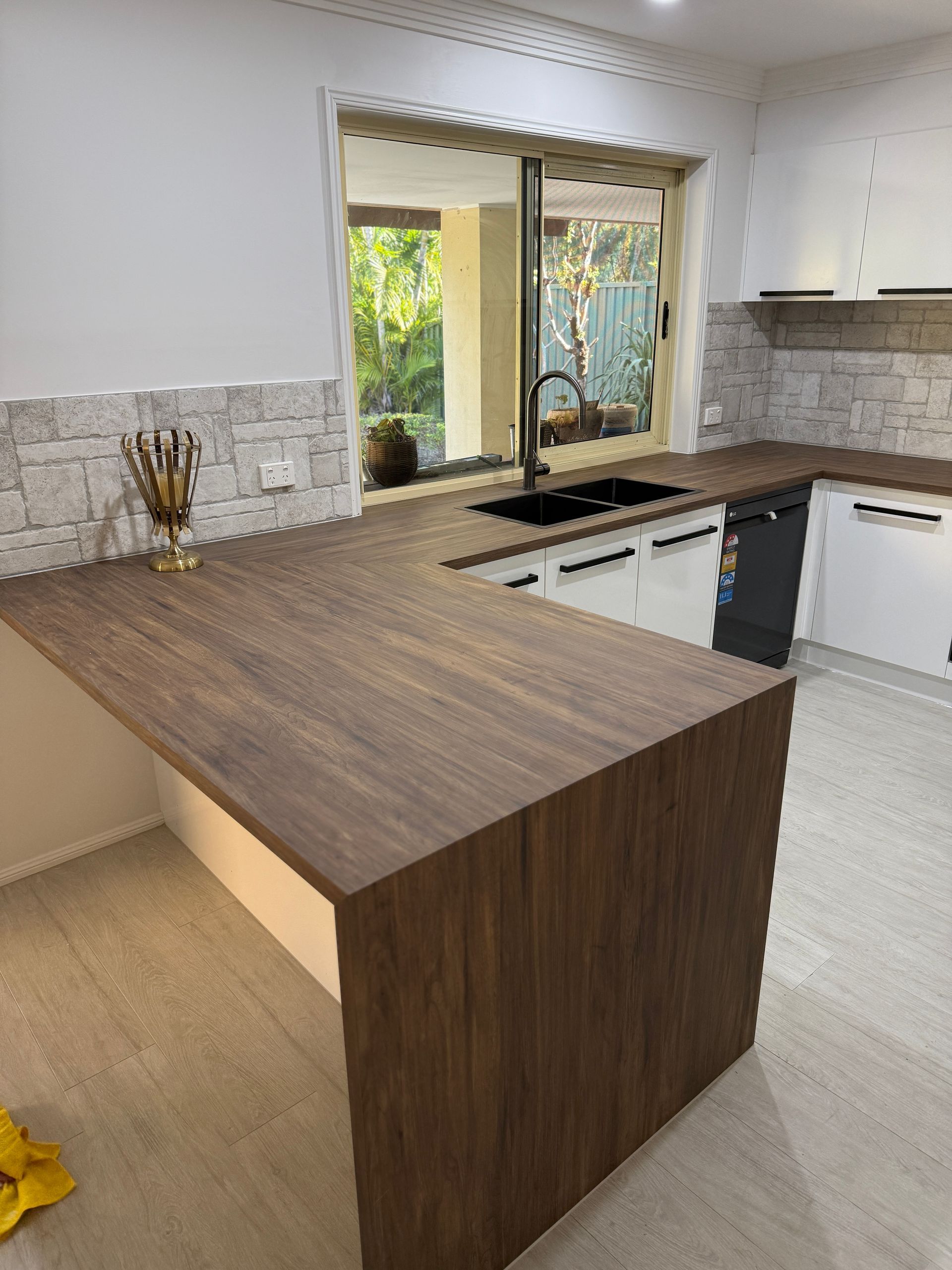 Modern Kitchen with Wood Island, White Cabinets, and Tiled Backsplash — JPR Concepts in Burleigh Heads, QLD