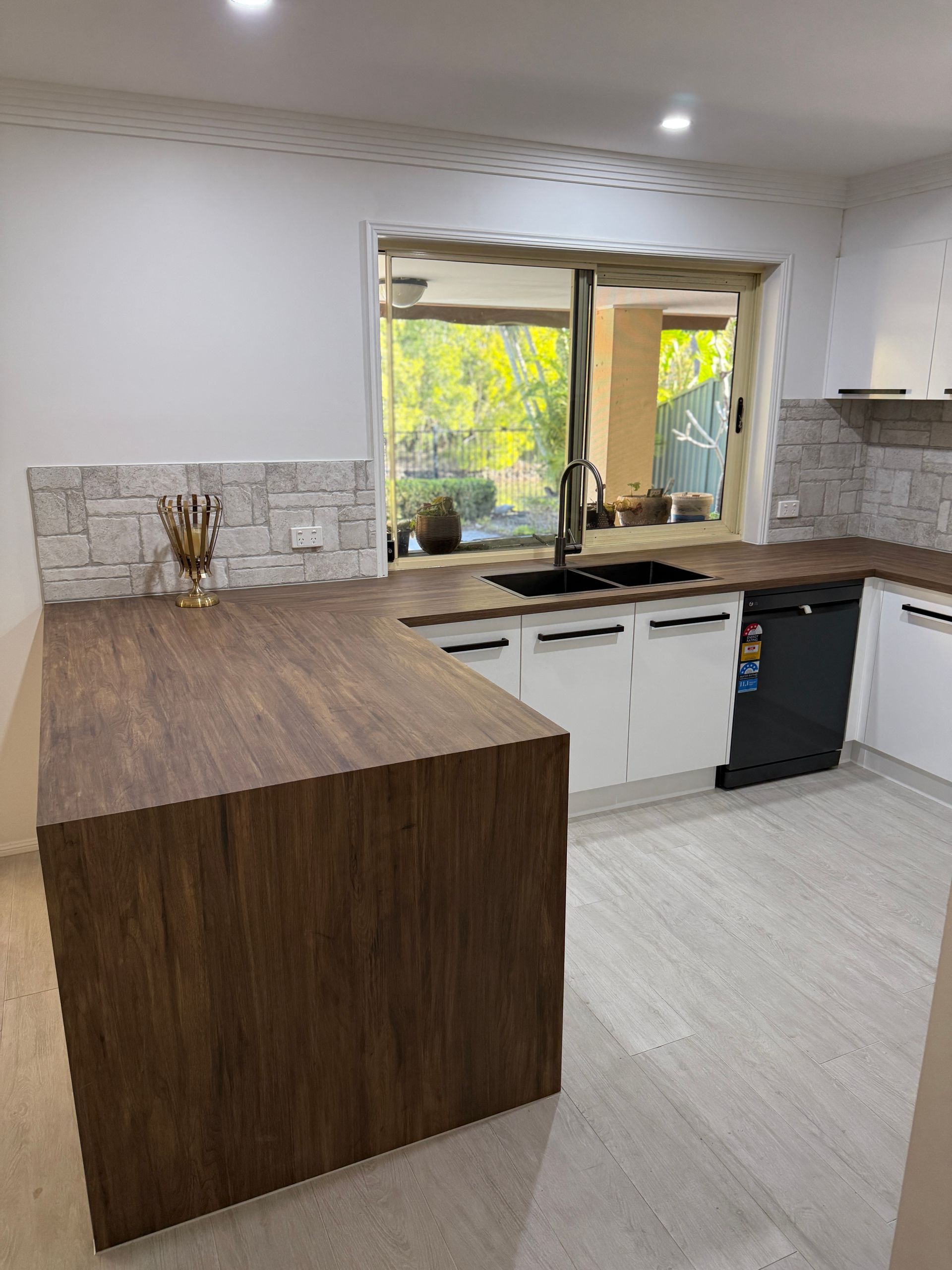 Modern Kitchen with Dark Wood Island and White Cabinets — JPR Concepts in Burleigh Heads, QLD