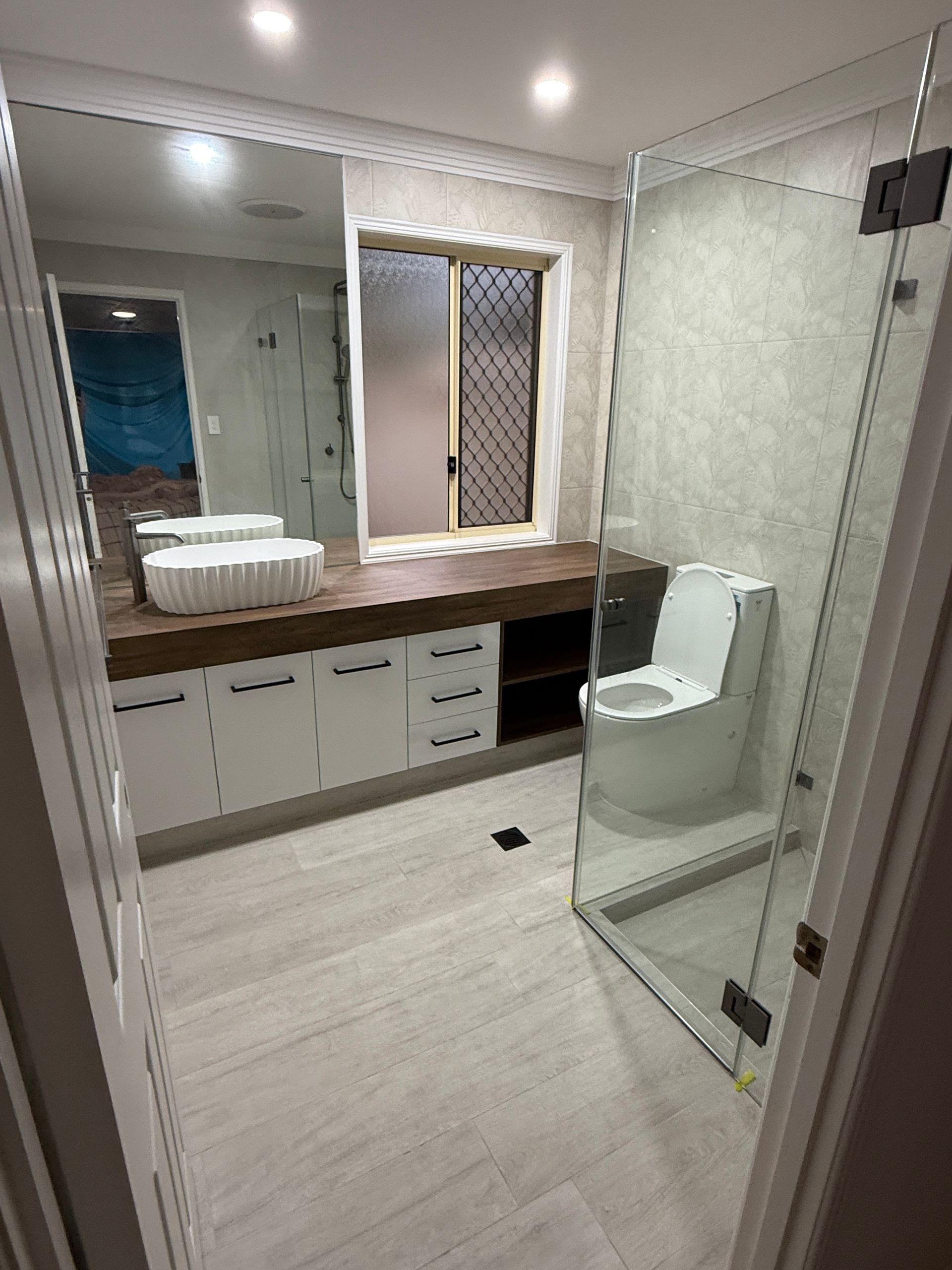 Bright Bathroom with Vanity, Mirror, Sink, Toilet, and Glass Shower Door — JPR Concepts in Burleigh Heads, QLD