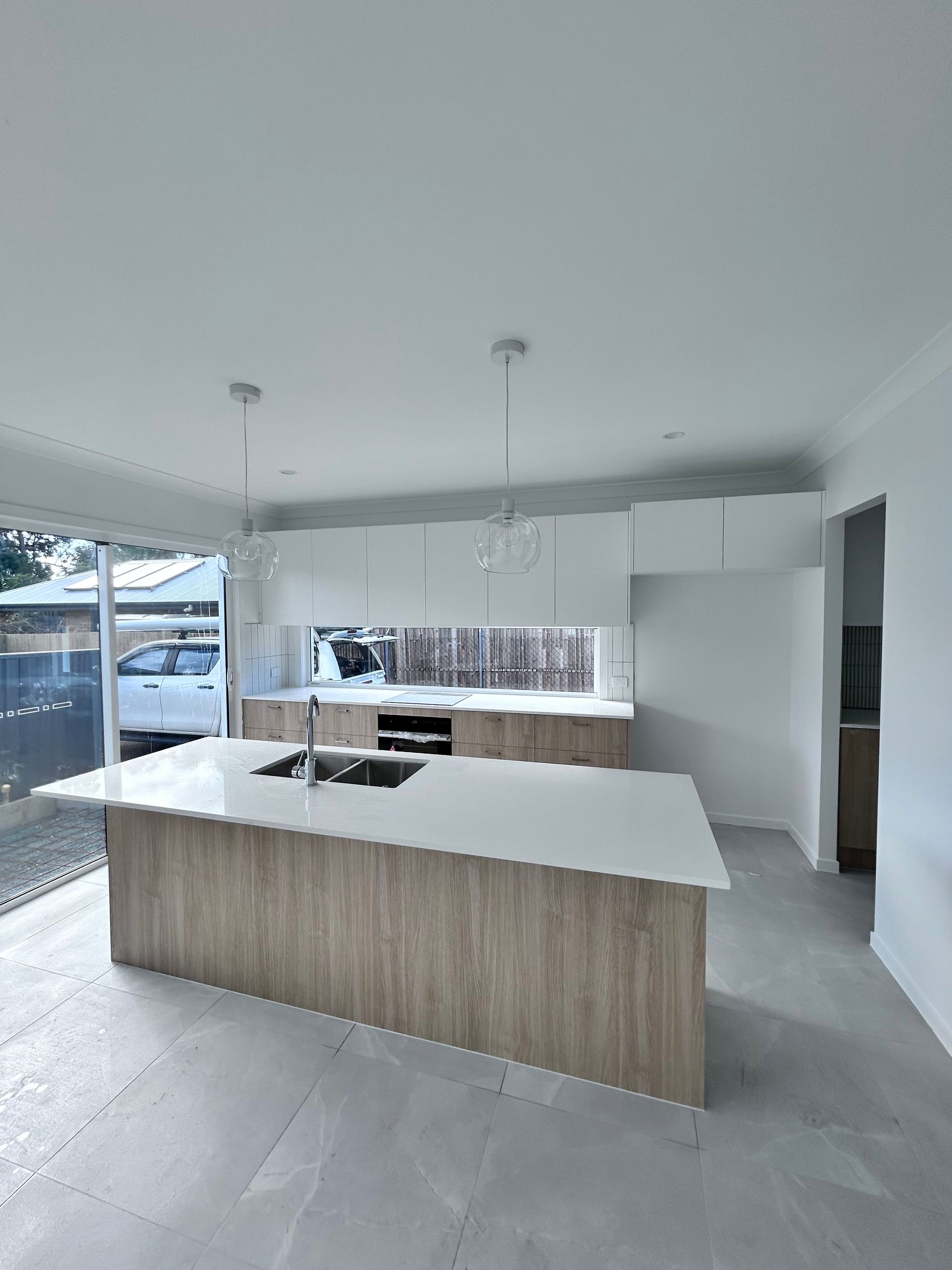 Modern White Kitchen with Large Island and Open Floor Plan — JPR Concepts in Burleigh Heads, QLD