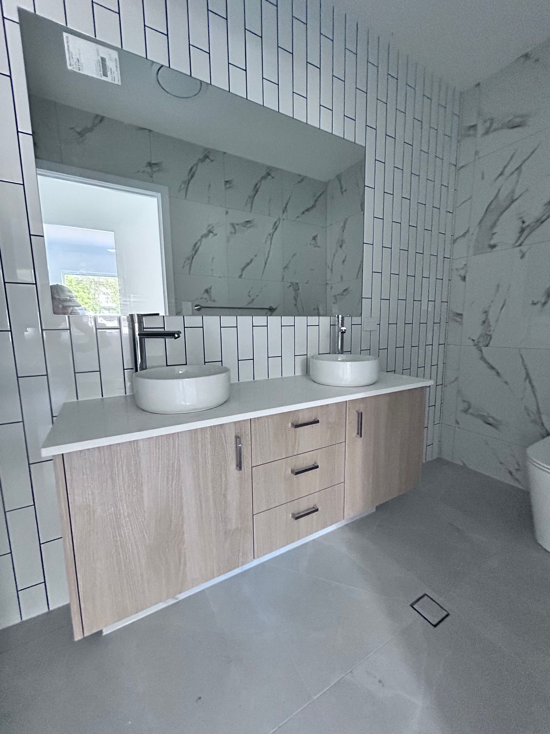 Modern Bathroom Vanity with  Light Wood Cabinets and Marble Patterned Tile Walls — JPR Concepts in Burleigh Heads, QLD