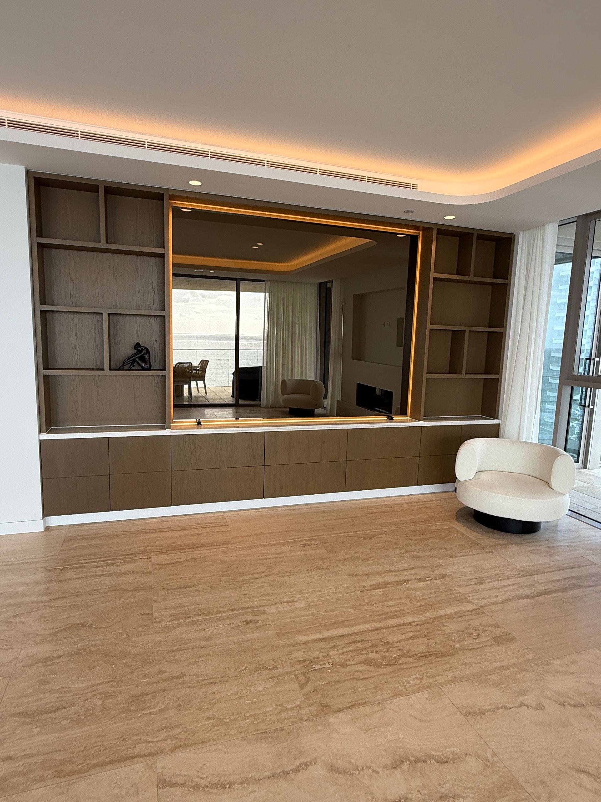 Modern Living Room with Built In Wooden Shelving and A White Chair on A Woven Floor — JPR Concepts in Burleigh Heads, QLD