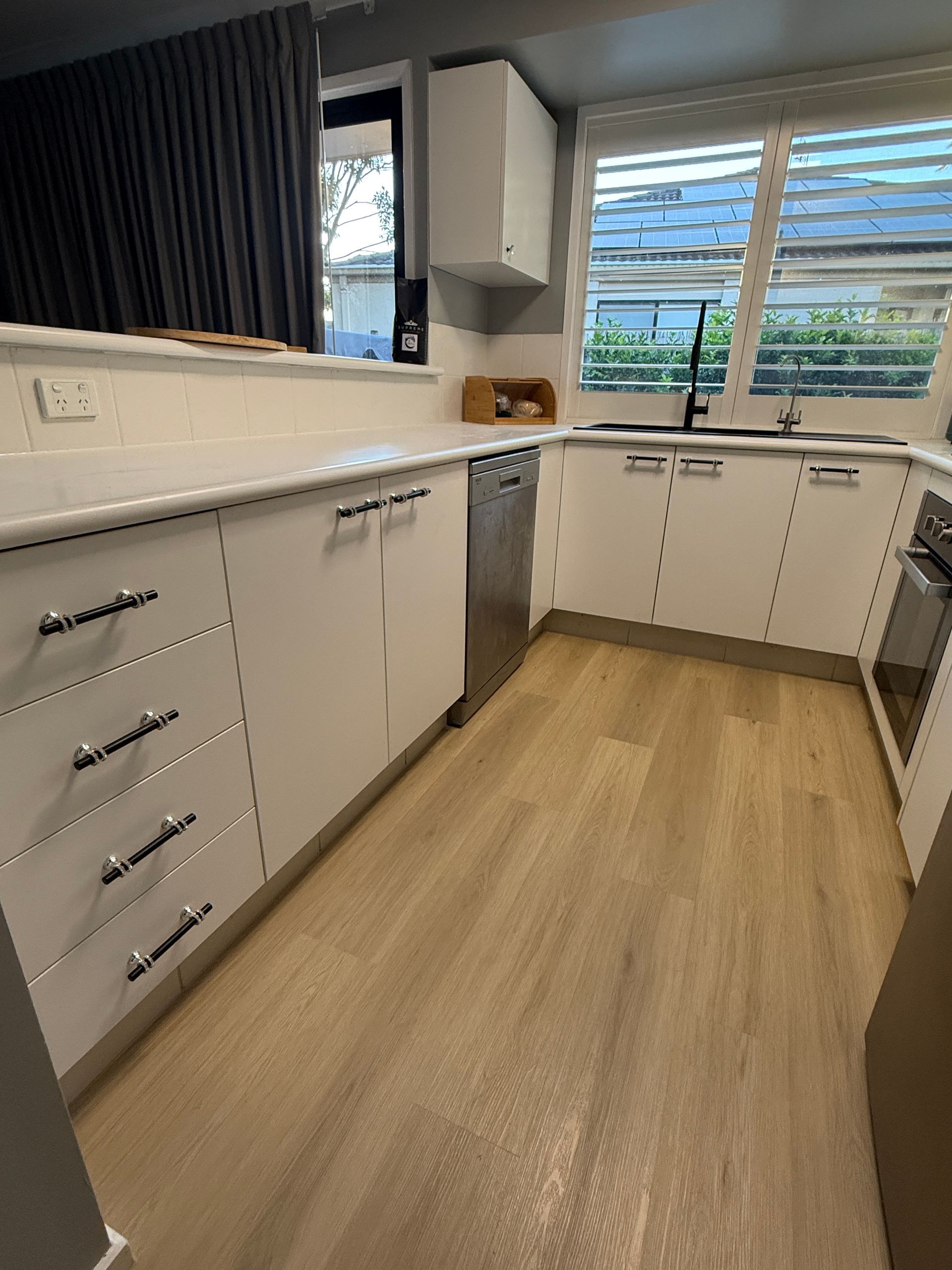 Modern Kitchen with White Cabinets and Wood Look Floor — JPR Concepts in Burleigh Heads, QLD