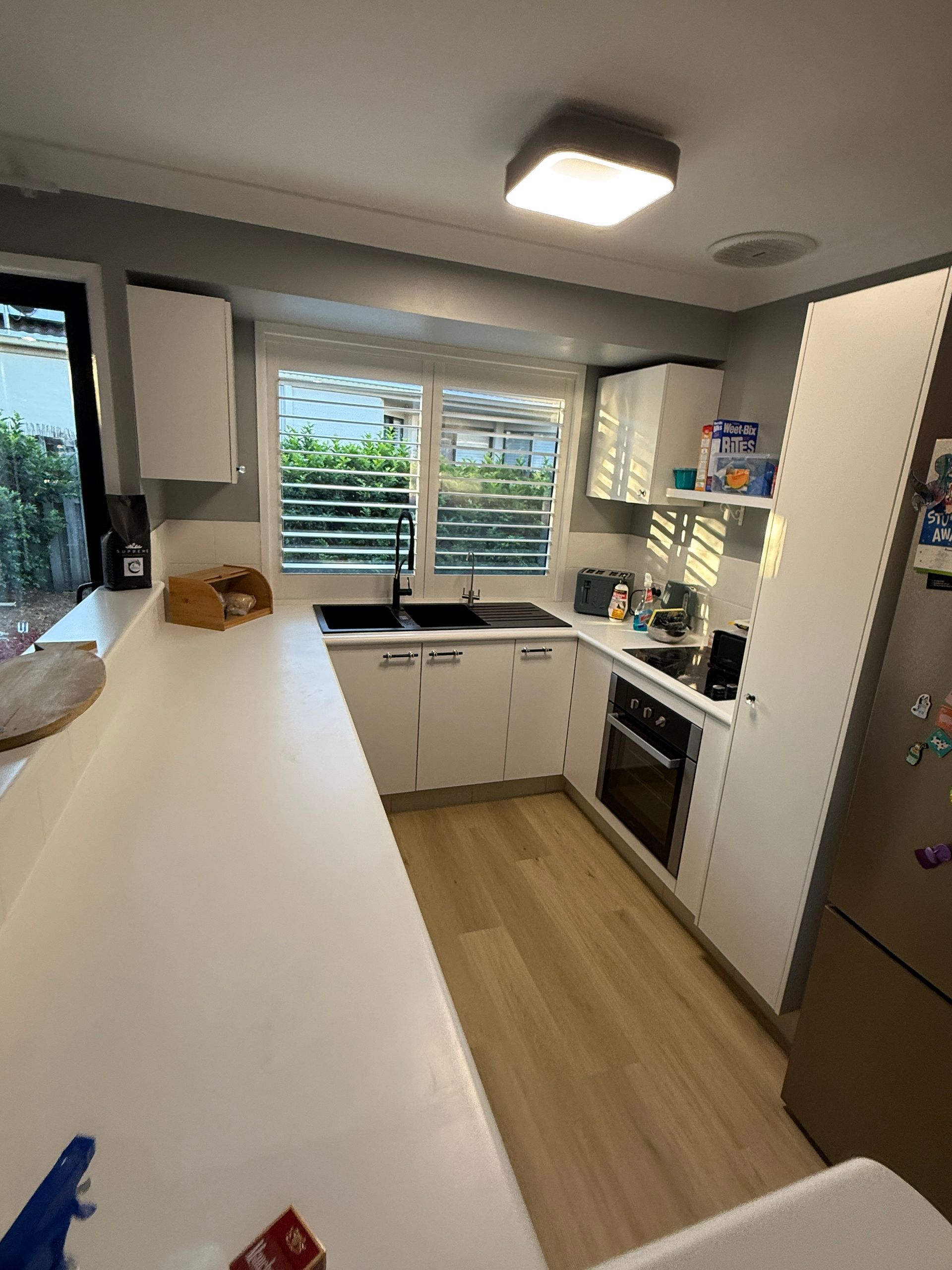 Bright Kitchen with White Counters and Wood Floor — JPR Concepts in Burleigh Heads, QLD