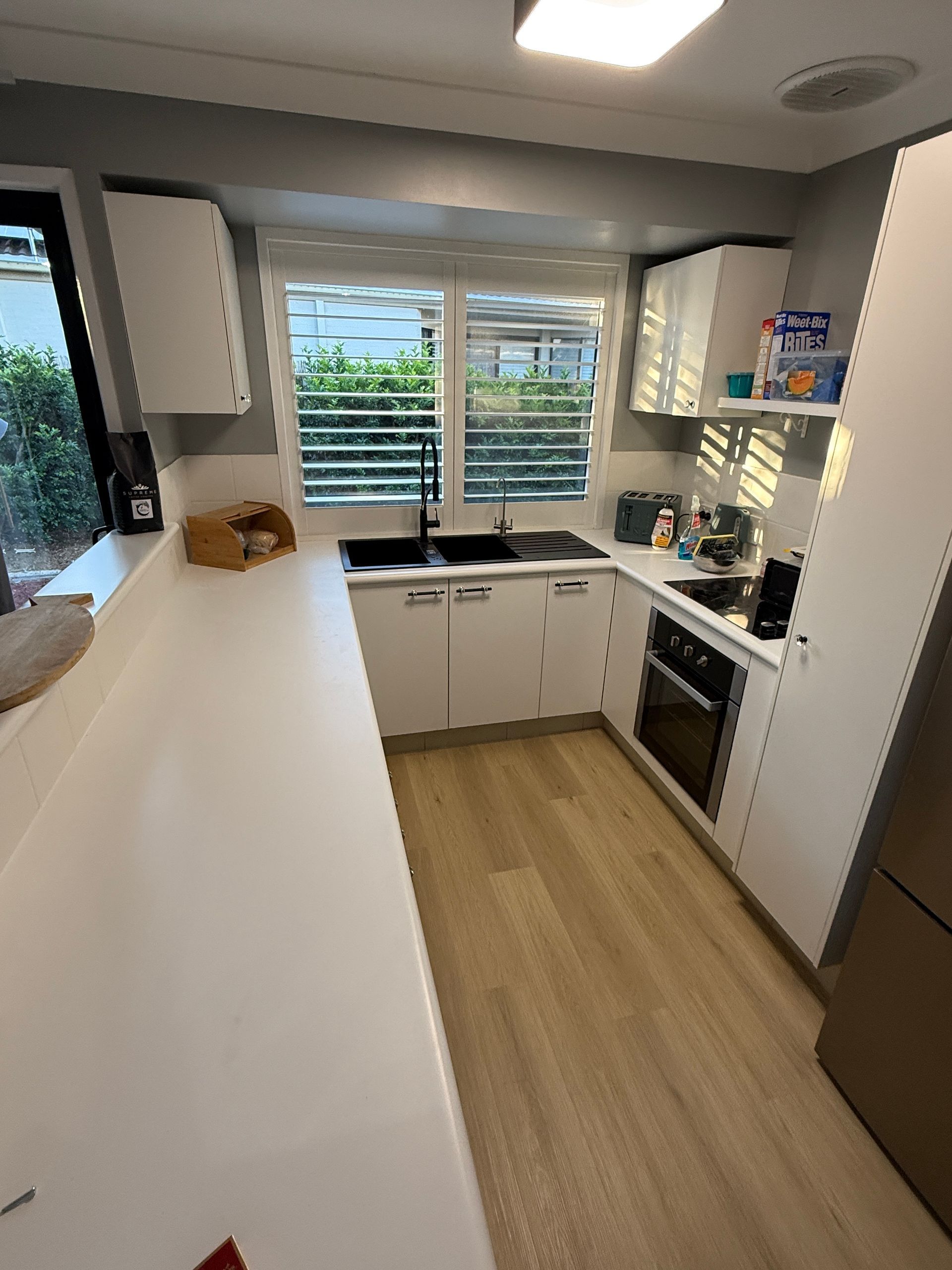 Small Modern Kitchen with White Cabinets and Long White Counter — JPR Concepts in Burleigh Heads, QLD
