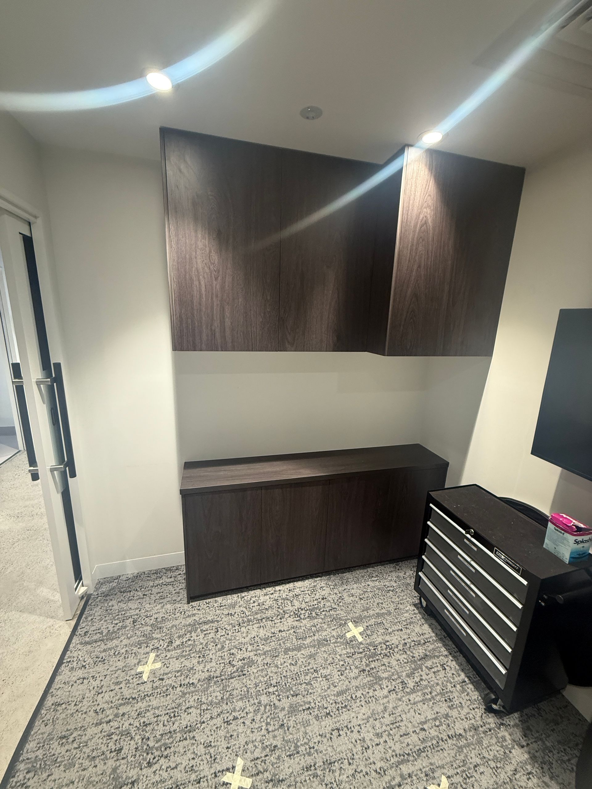 Small Room with Dark Wall Cabinets, a Countertop, and A Rolling Tool Chest on Carpet — JPR Concepts in Burleigh Heads, QLD