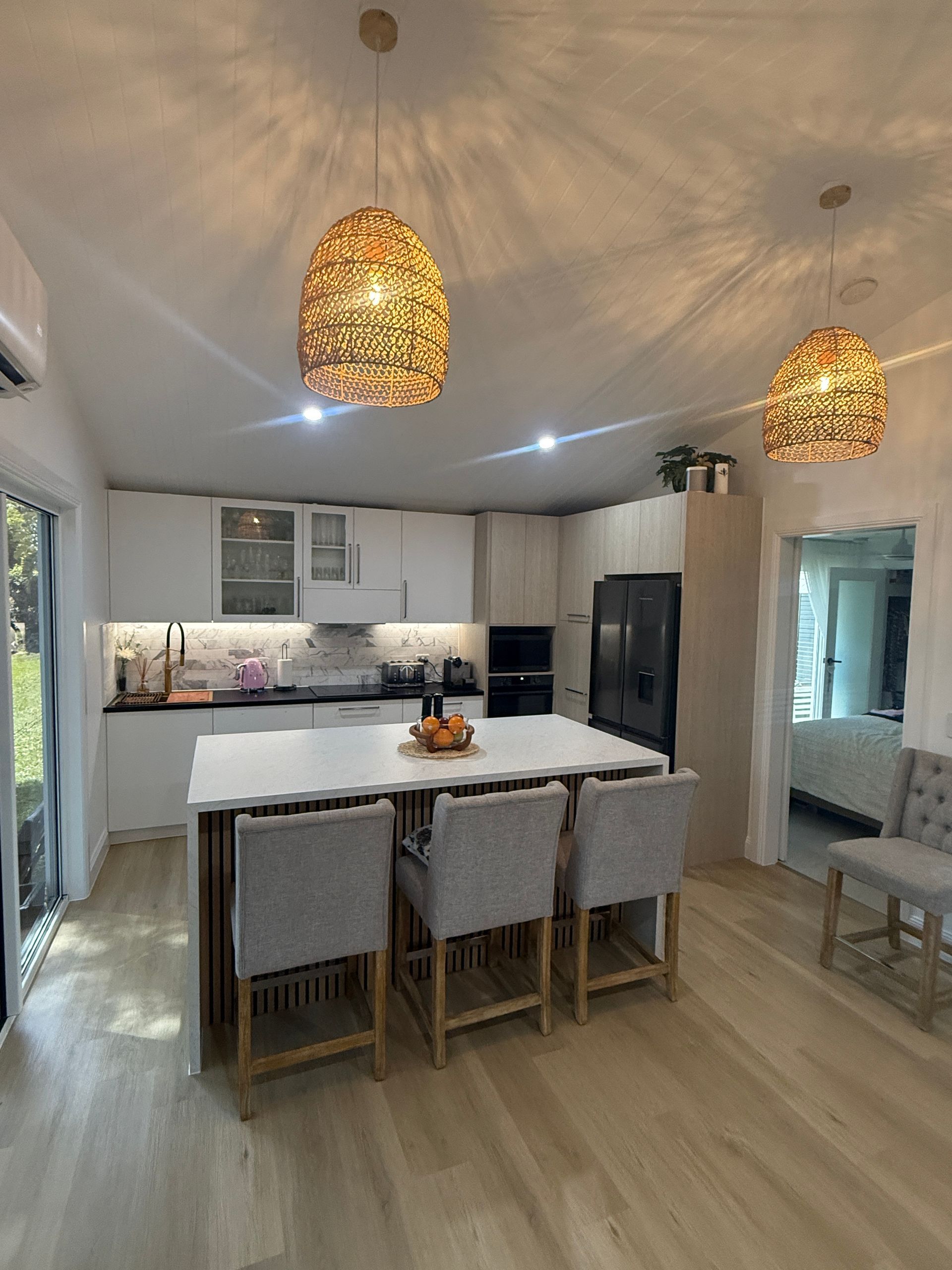 Bright Modern Kitchen with Island, Chairs, Cabinets, and Woven Pendant Lights — JPR Concepts in Burleigh Heads, QLD
