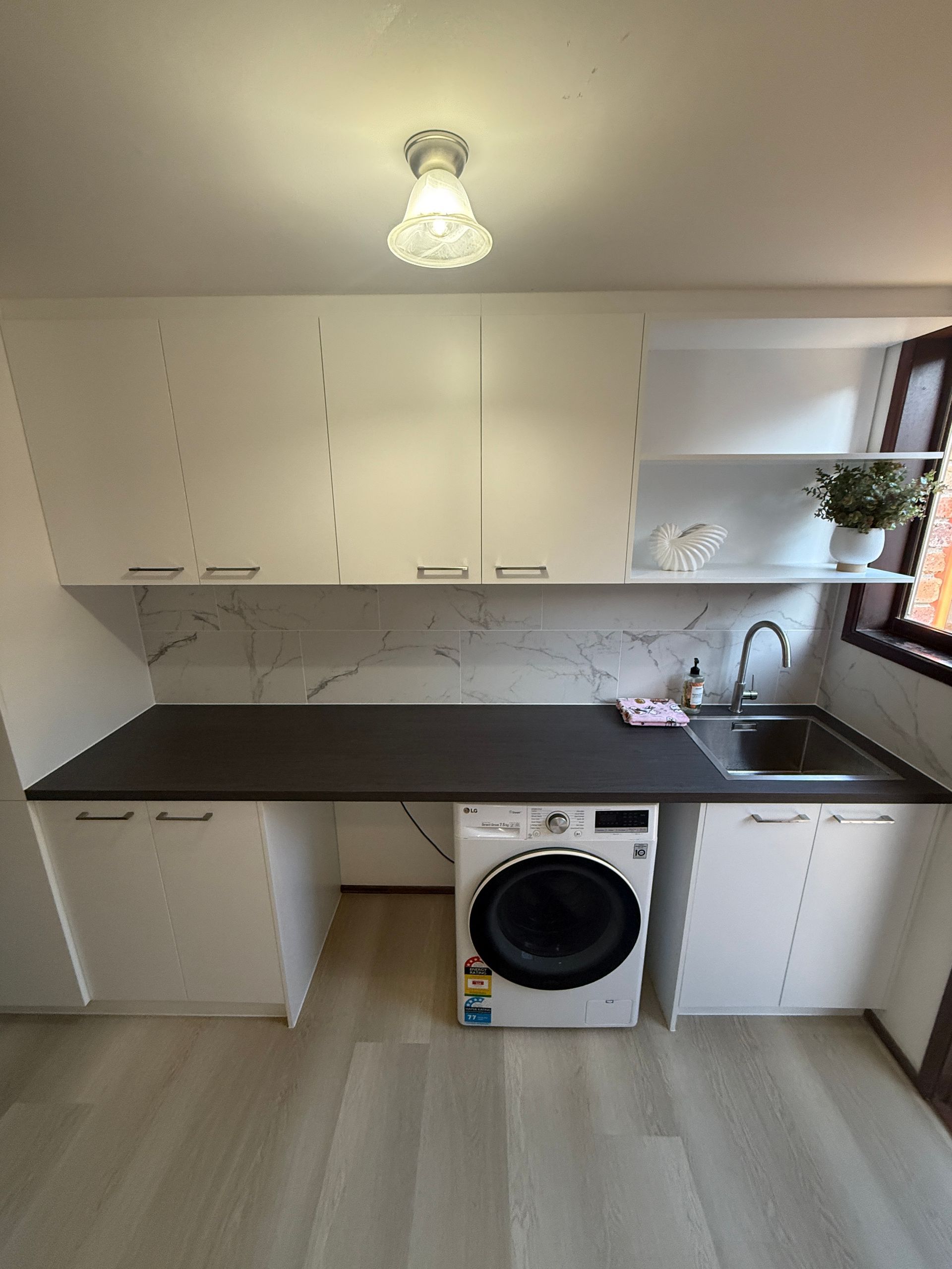 Small White Laundry Room with Black Countertop — JPR Concepts in Burleigh Heads, QLD