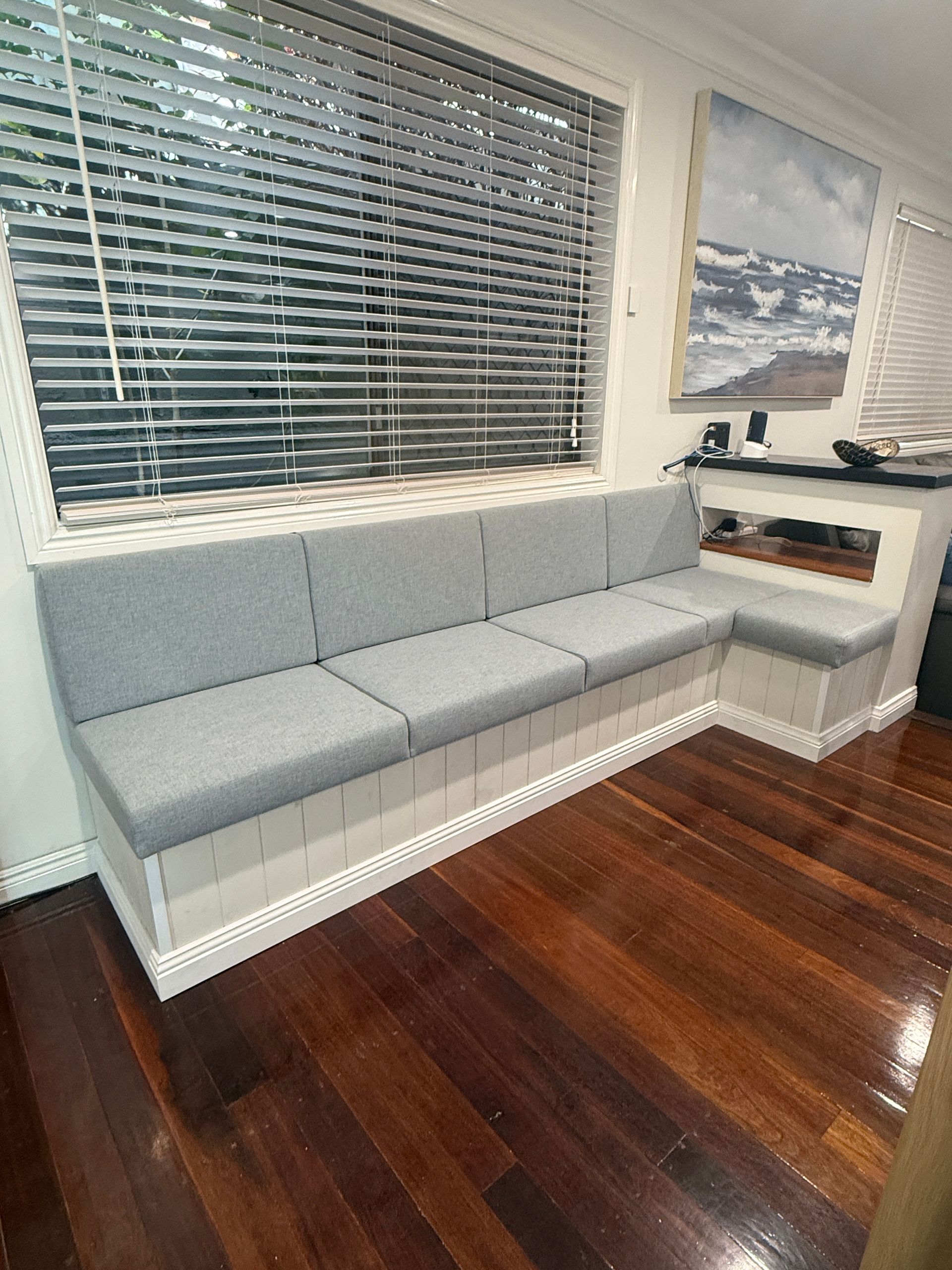 Gray Built In Window Bench with Cushions Beside Blinds in A Room with Dark Wood Floors — JPR Concepts in Burleigh Heads, QLD