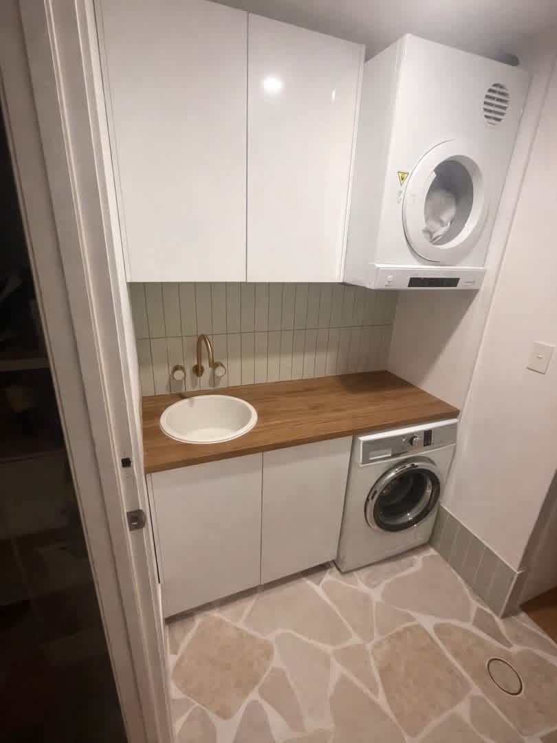Small Compact Laundry Room with Wood Countertop and Stacked Washer Dryer — JPR Concepts in Burleigh Heads, QLD