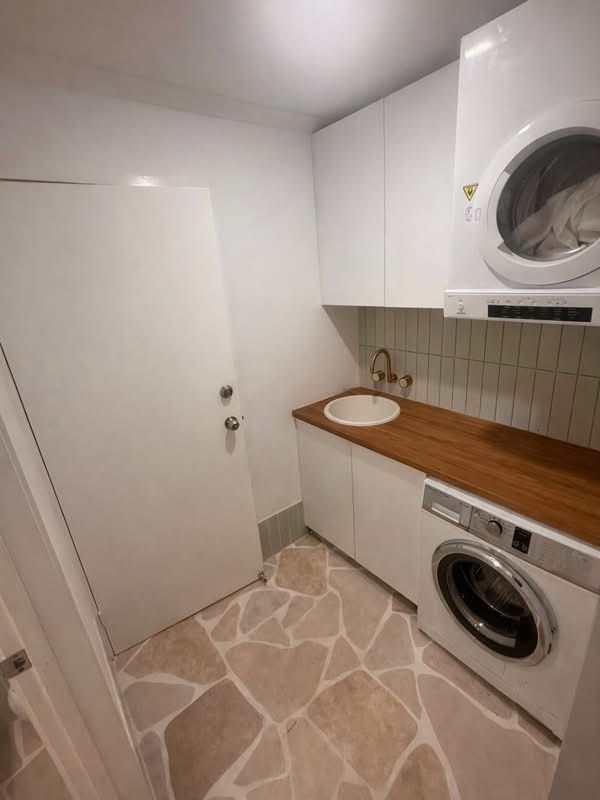 Compact Laundry Room with Washer and Wood Countertop — JPR Concepts in Burleigh Heads, QLD