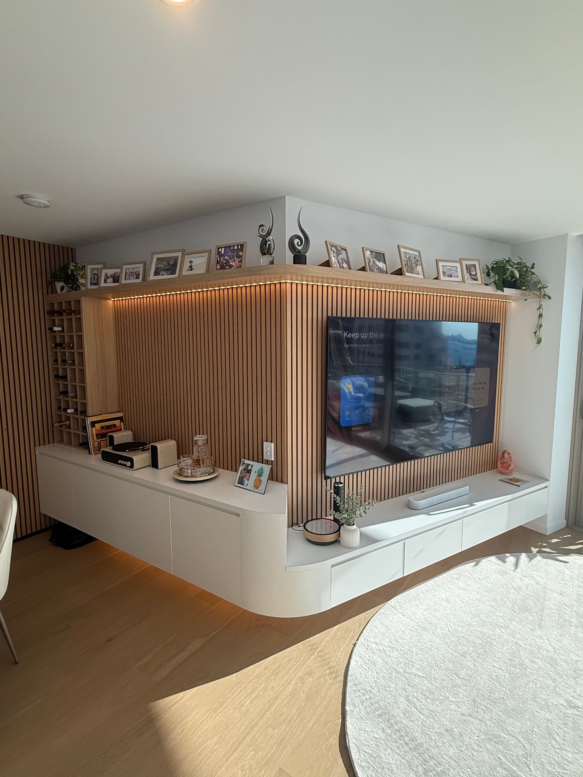 Modern Living Room with Built In Curved TV Wall and Warm Wood Slats — JPR Concepts in Burleigh Heads, QLD