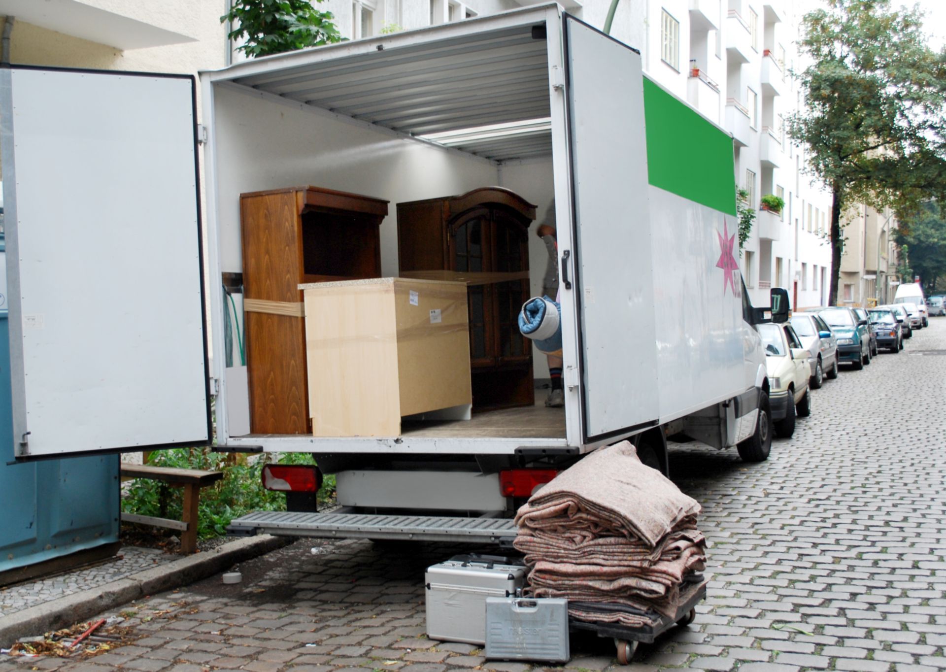 Open back of a moving truck parked on a city street.