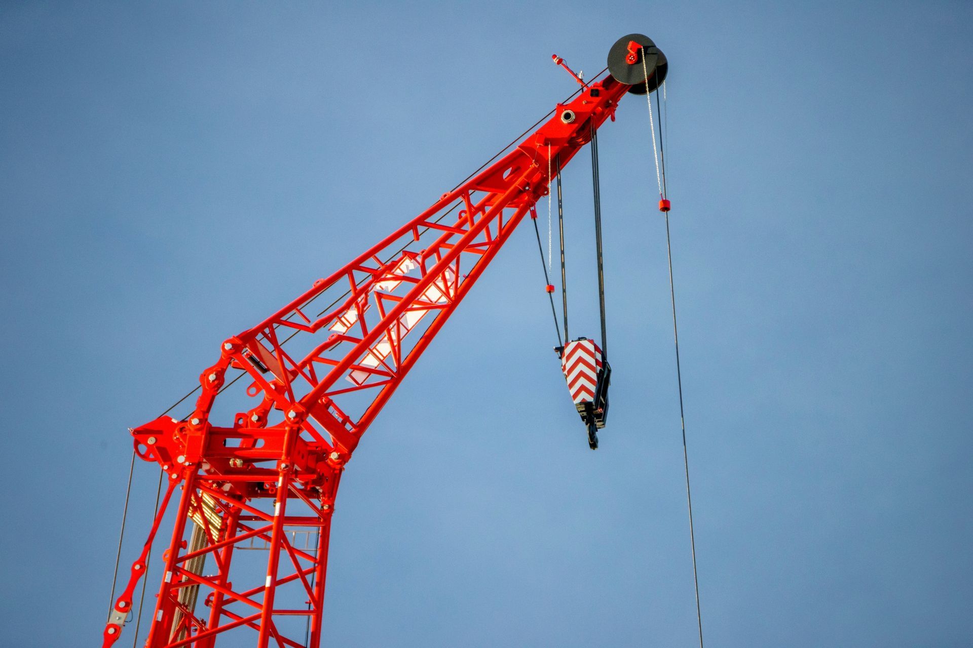 A red crane is against a blue sky.