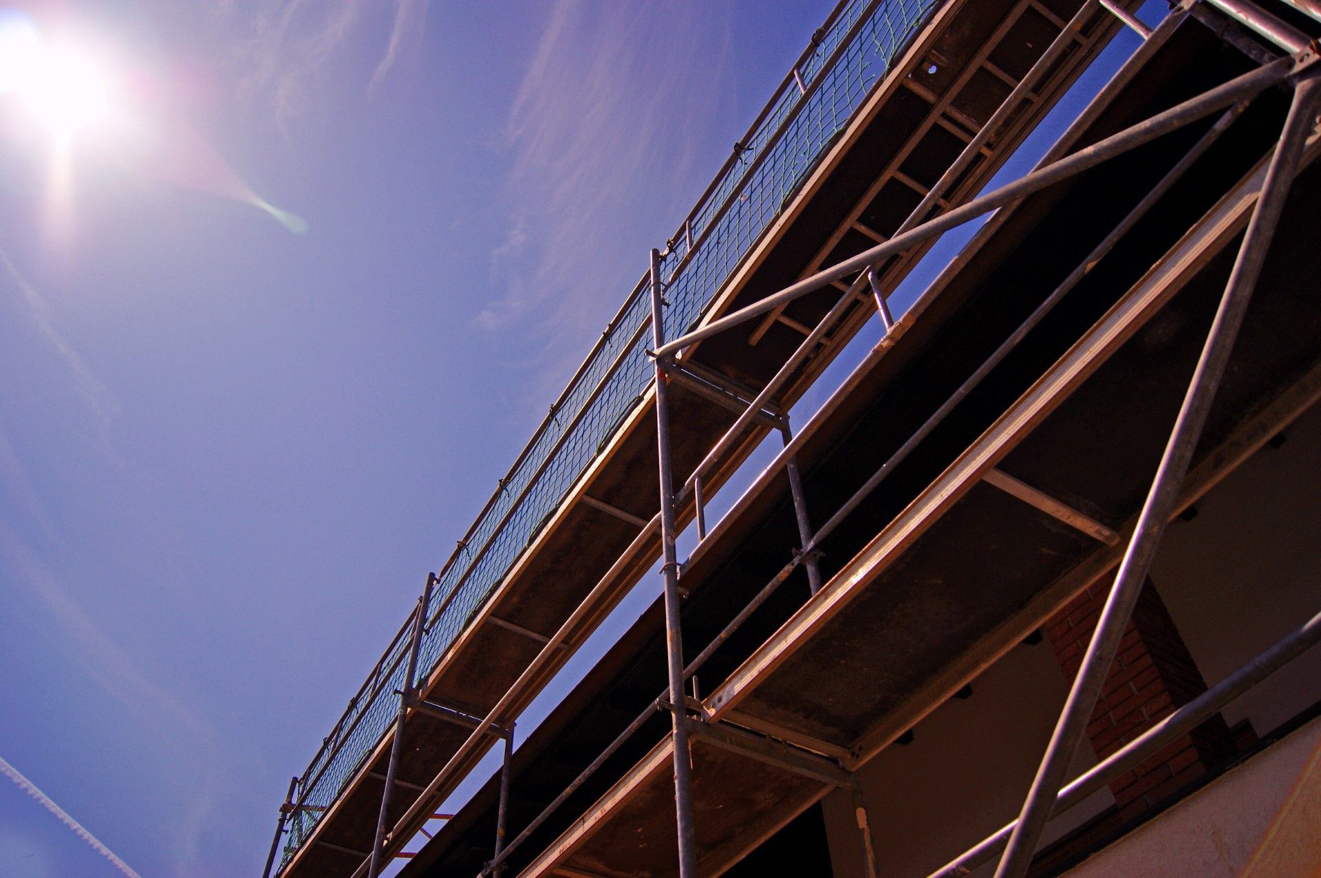 A building under construction with scaffolding and a blue sky in the background