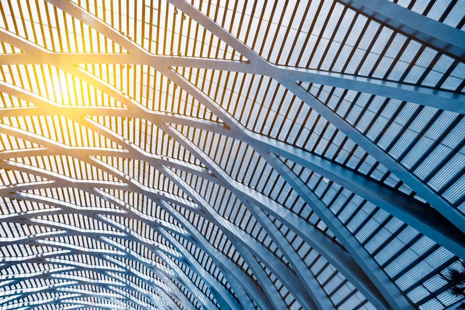 Looking up at the ceiling of a building with the sun shining through it.