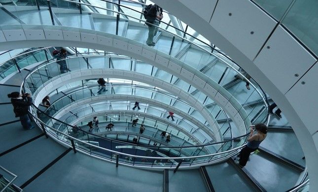 People are walking down a spiral staircase in a building