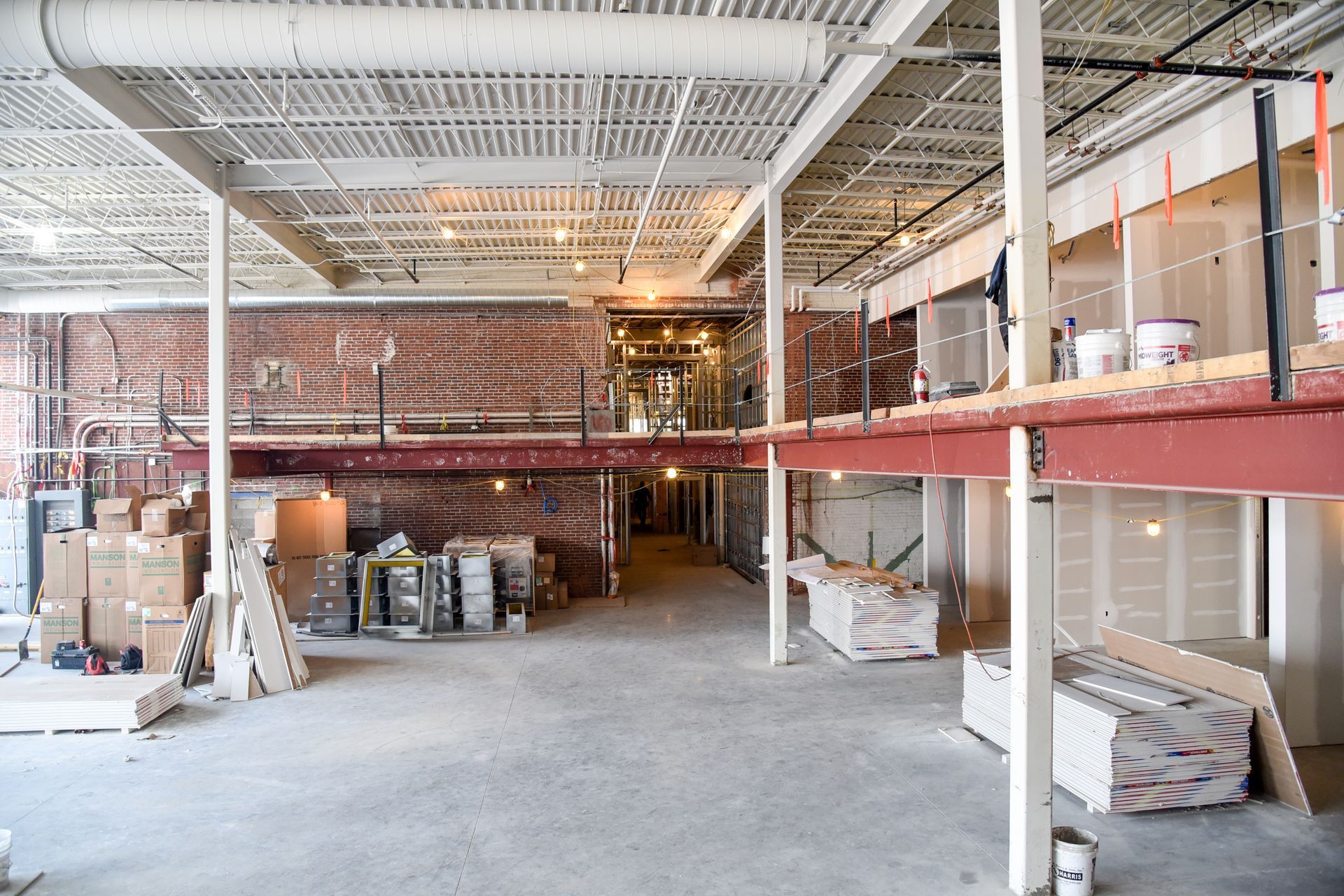 The inside of a building under construction with boxes on the floor.
