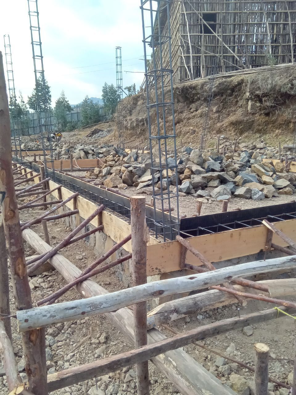 Construction site: wooden forms for a foundation with steel rebar, and support structure.