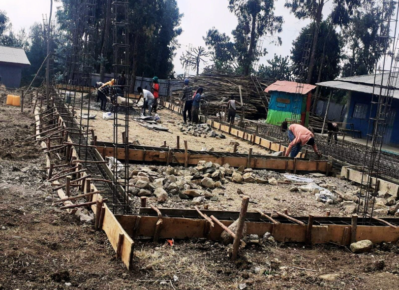Construction site with workers, wooden forms, and rebar.