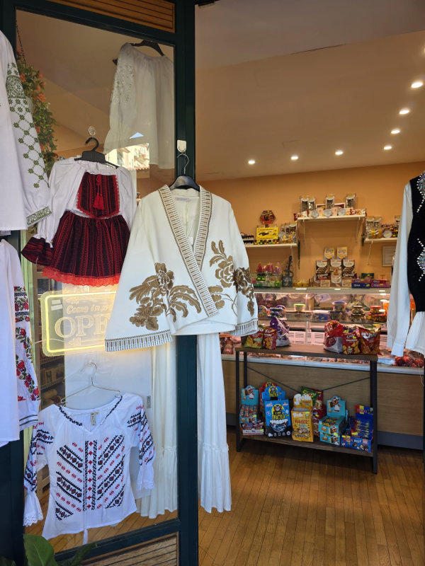 Vetrina di un negozio di abbigliamento con abiti tradizionali ricamati e cartello 