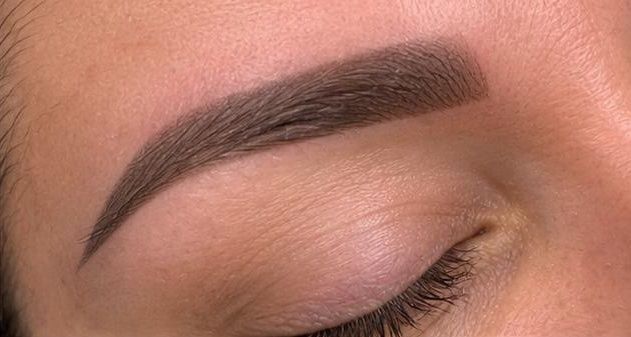 Close-up of a finished microblading brow with soft powder effect