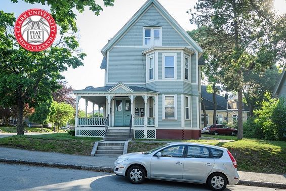 A car is parked in front of a house that says car university