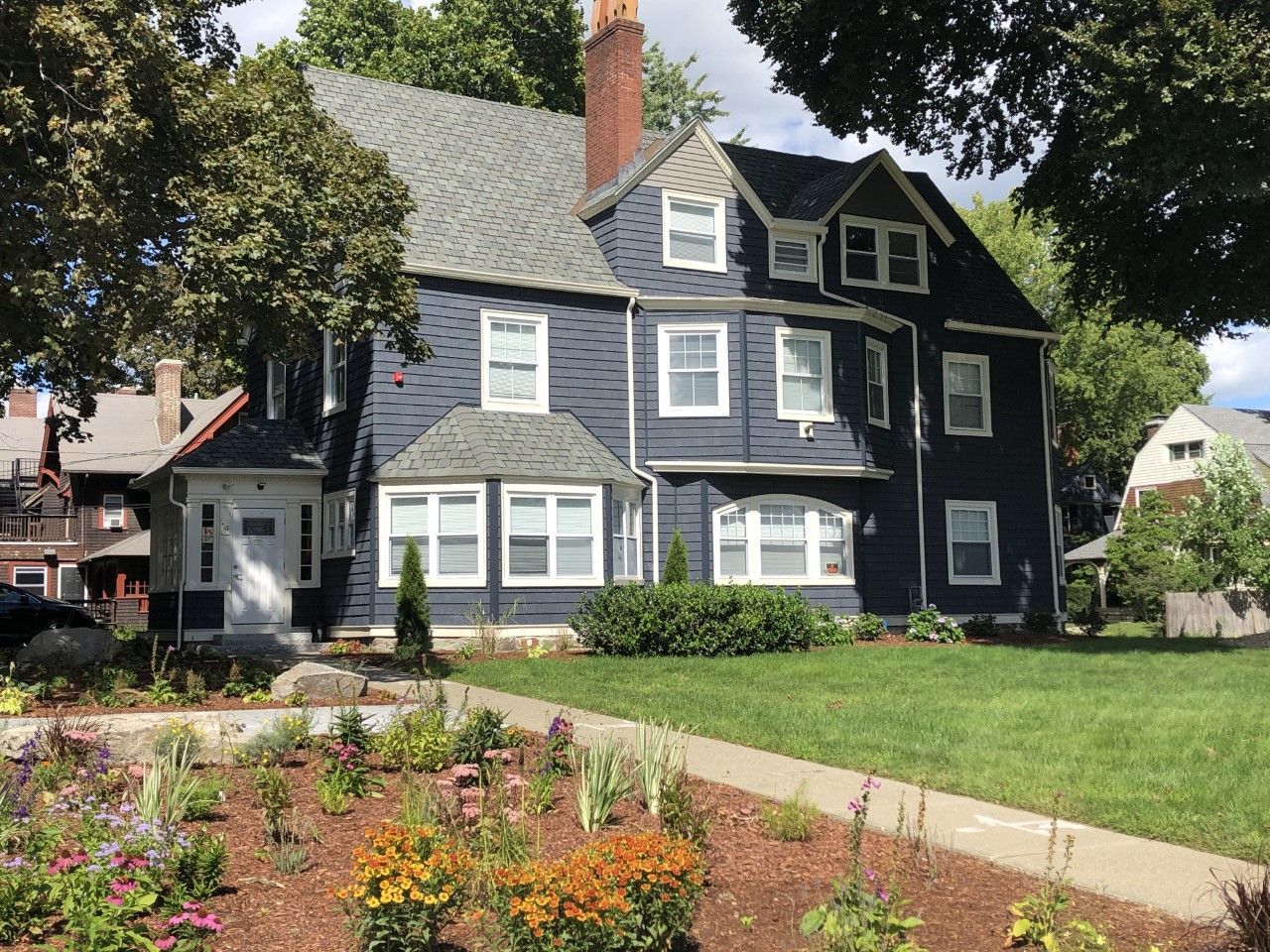 A large house with a lot of windows and flowers in front of it