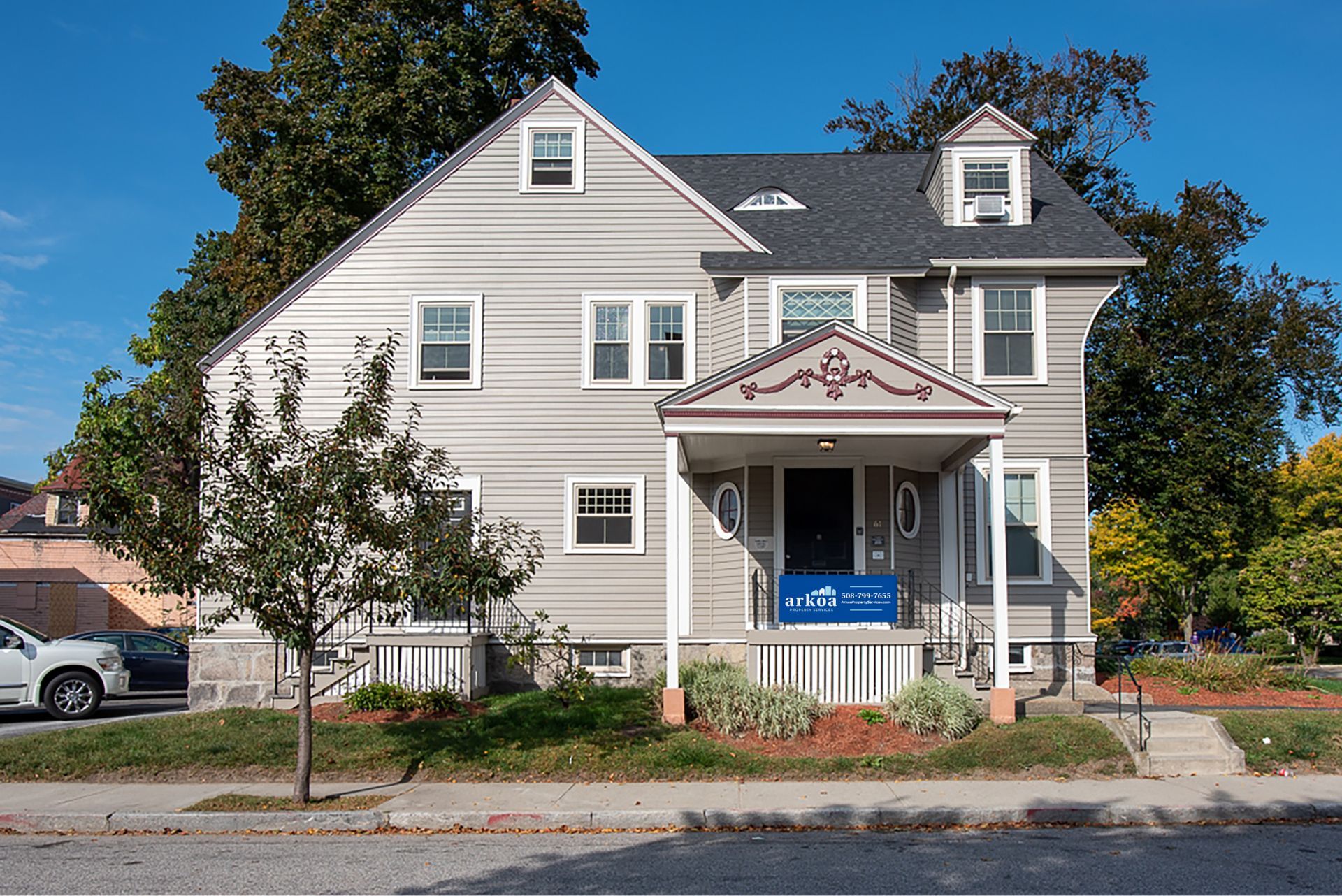 A house with a for sale sign on the front porch