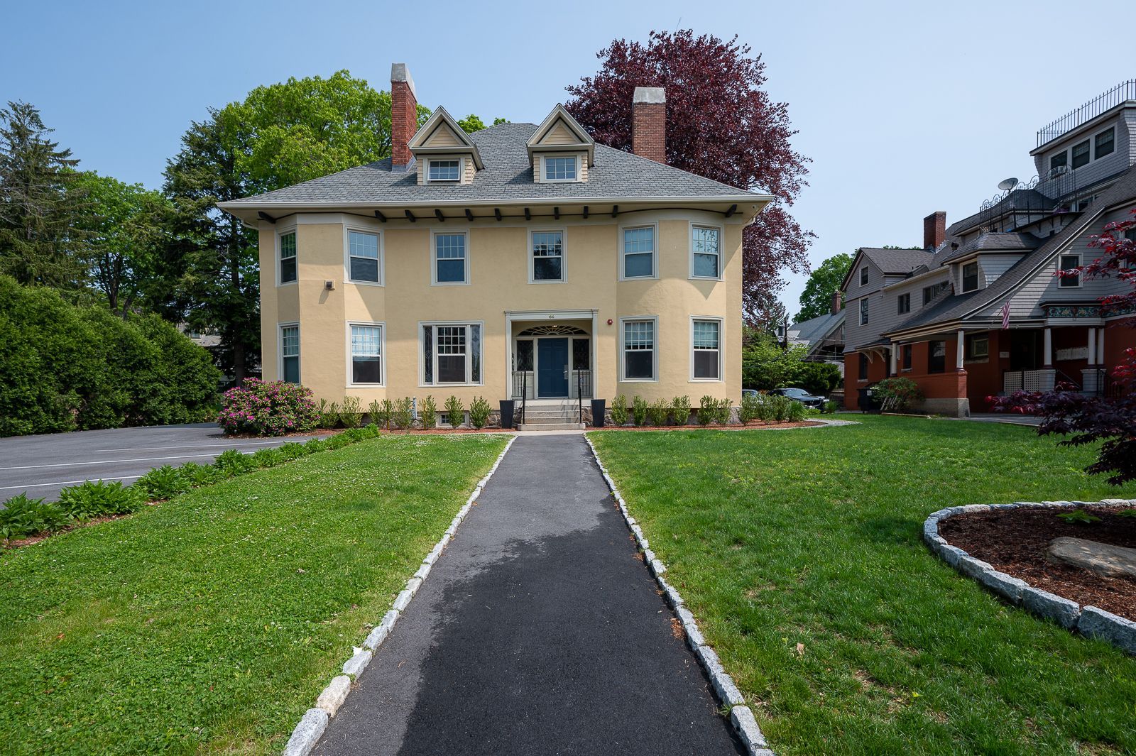 A large yellow house with a walkway leading to it