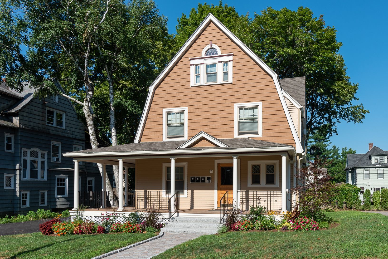 A large house with a large porch and a blue sky in the background
