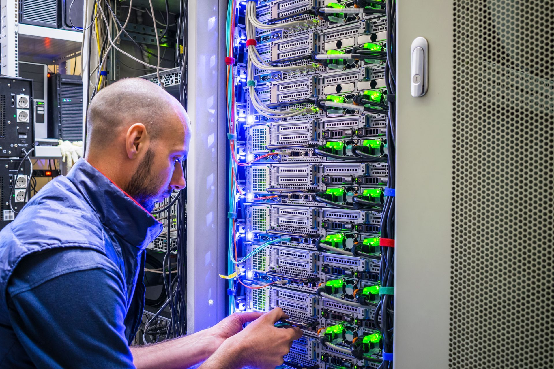 Close-up of network cables plugged into a router or switch with green status lights blinking