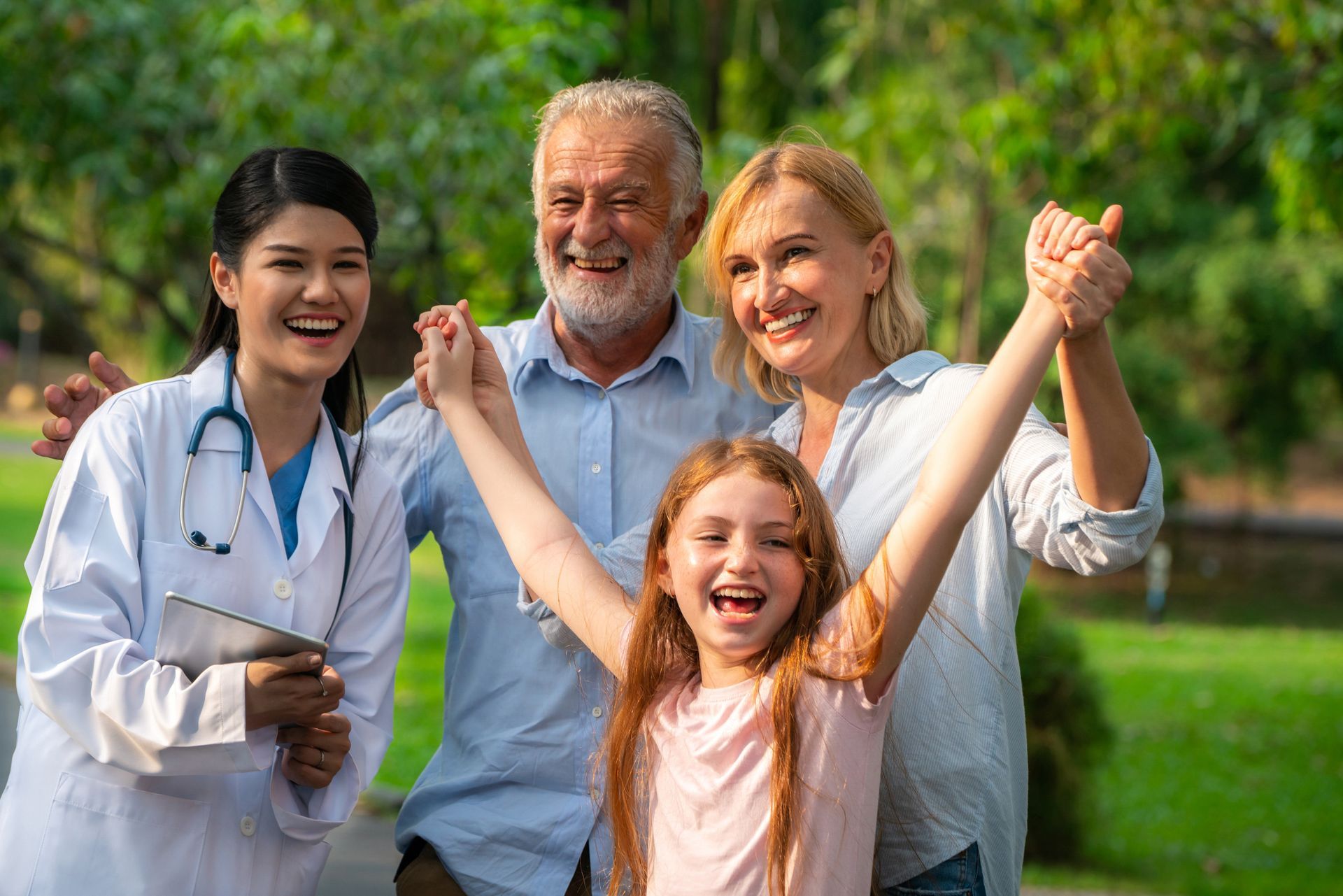 Happy healthy family and doctor talking in park. 

