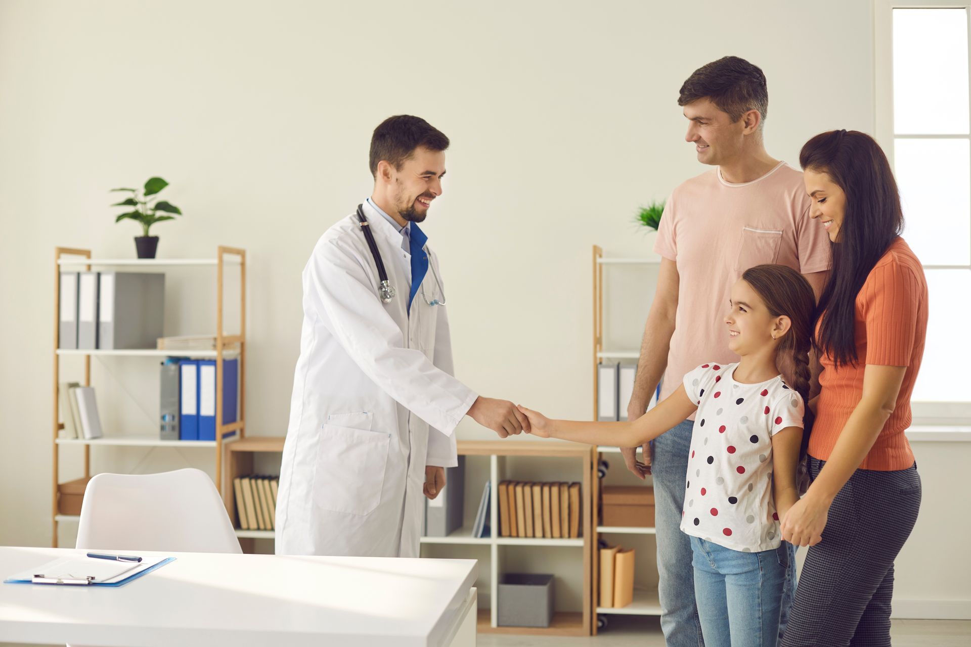 Happy mom, dad and child visiting hospital together.