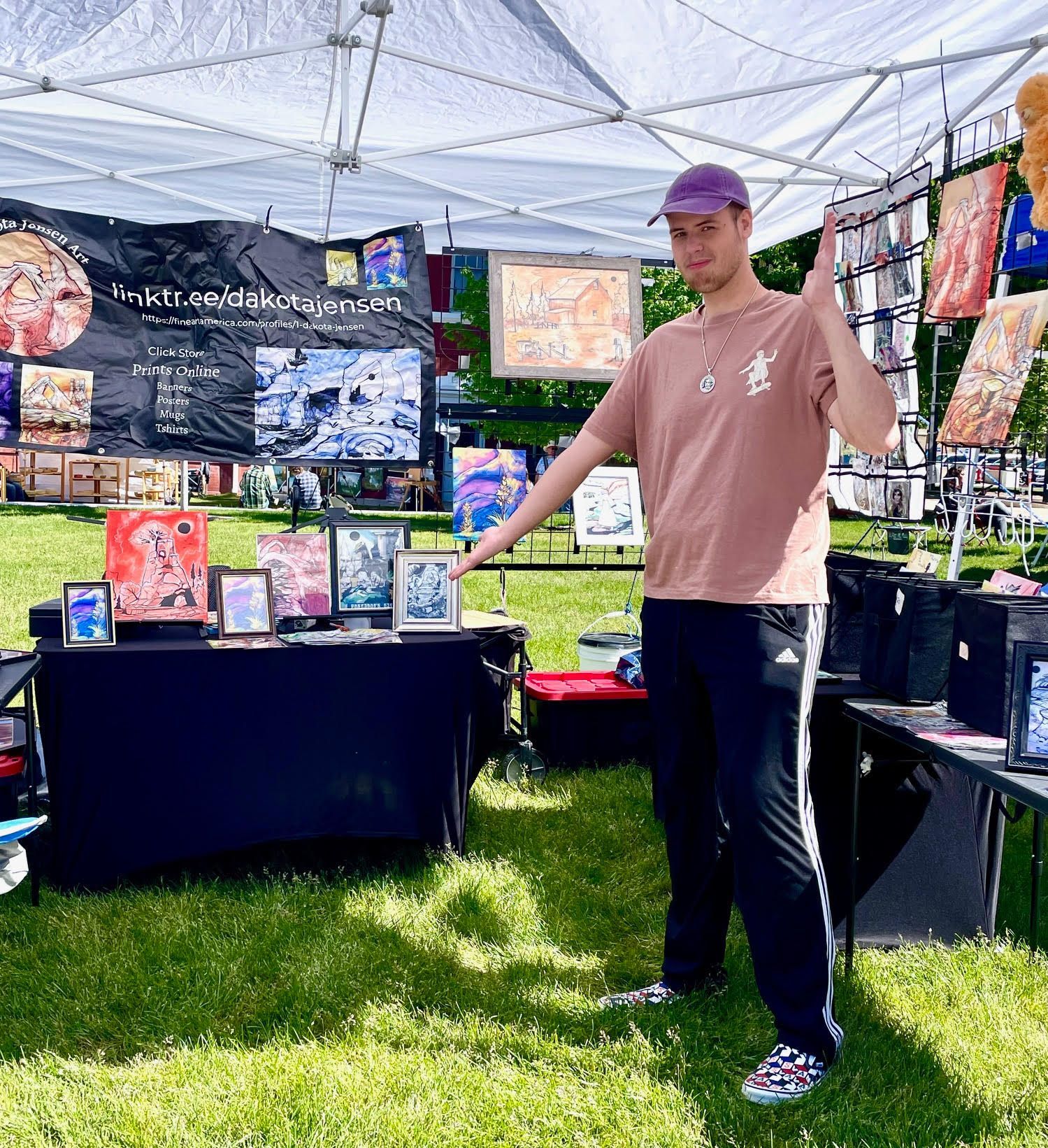 A man is standing in front of a table under a tent.