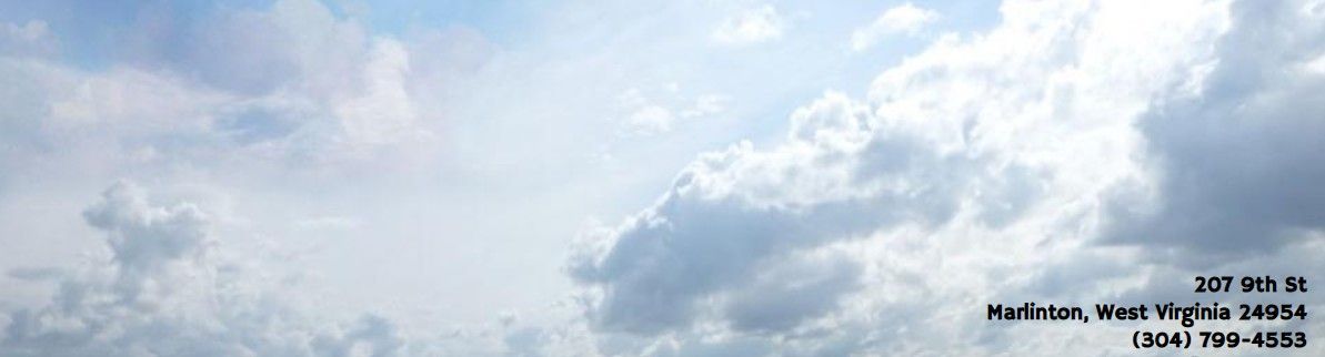 Cloudy blue sky with large white and gray clouds and a small black text watermark in the lower right.