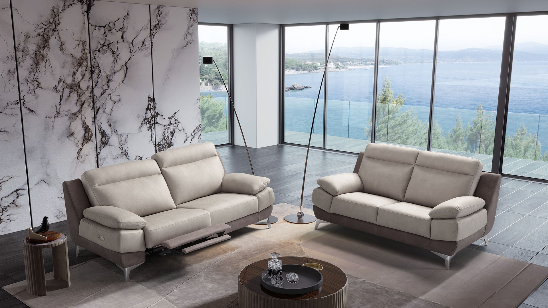 Soggiorno moderno con due divani beige, ampie finestre e vista sull'acqua.