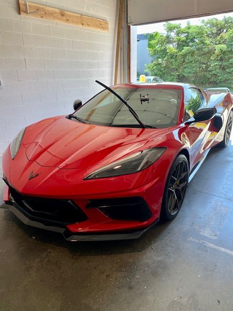 Red Chevrolet Corvette sports car parked inside a garage.