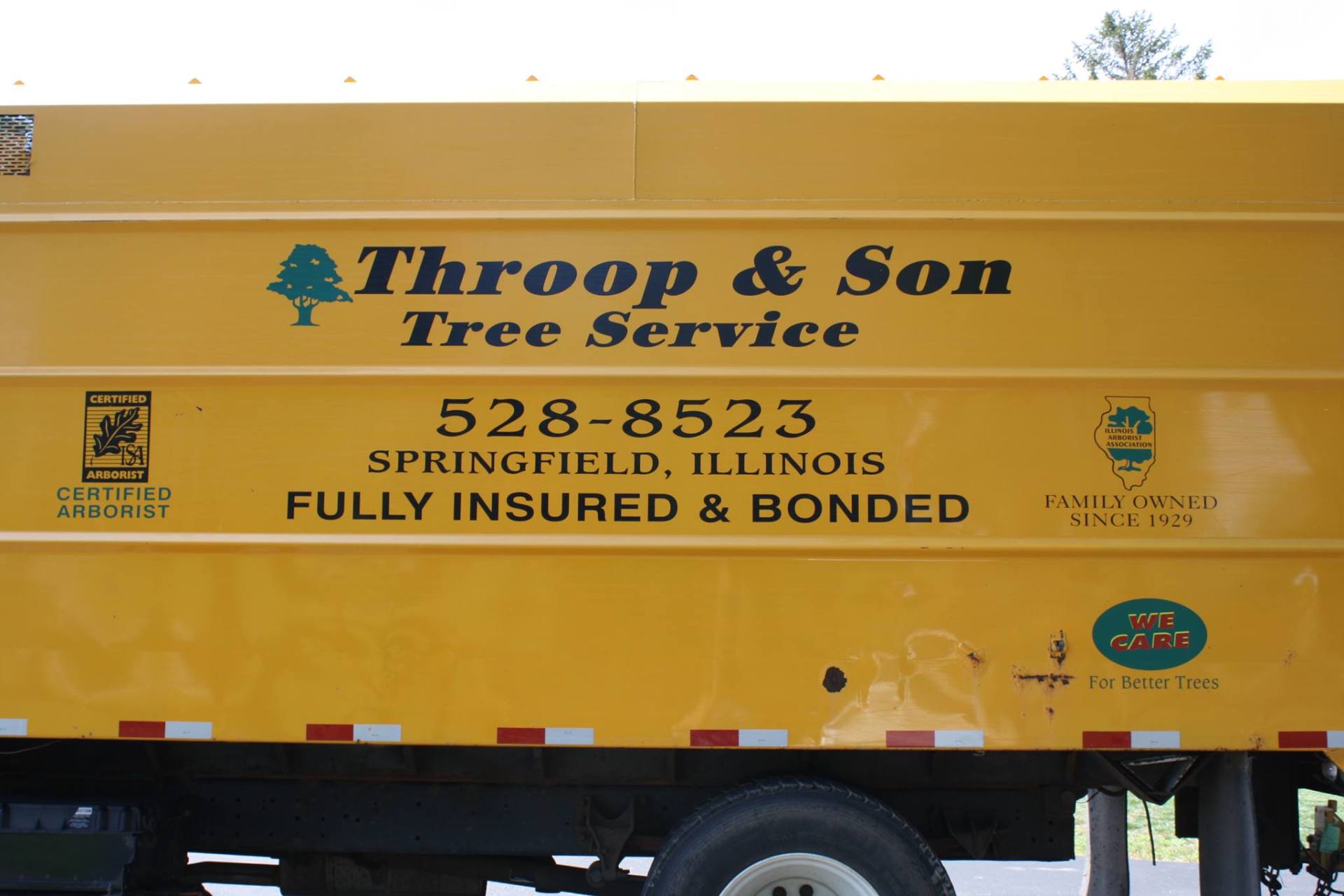 A yellow truck that says throop & son tree service