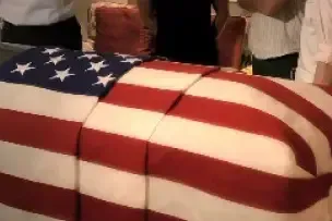 American flag draped over a casket at a funeral