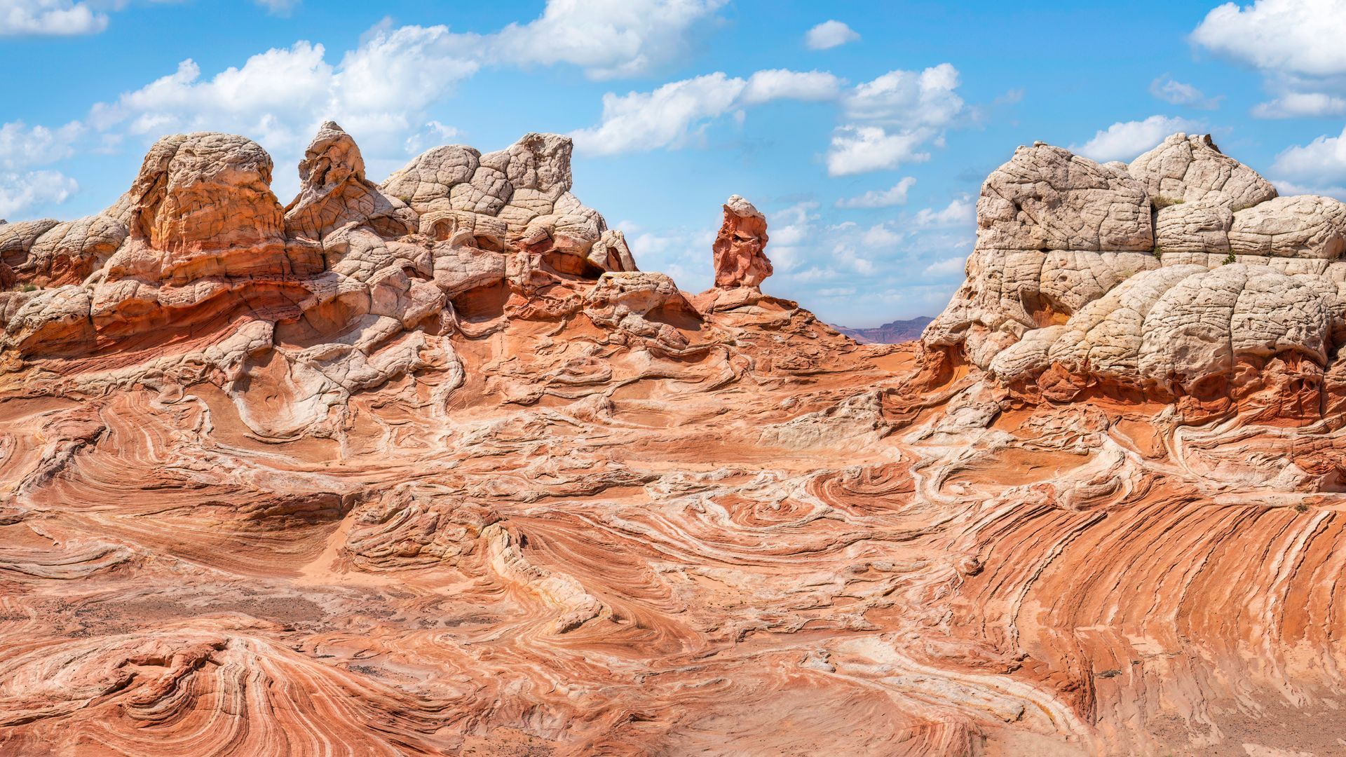 Sunlit canyon cliffs with layered rock formations and deep shadows under a clear blue sky