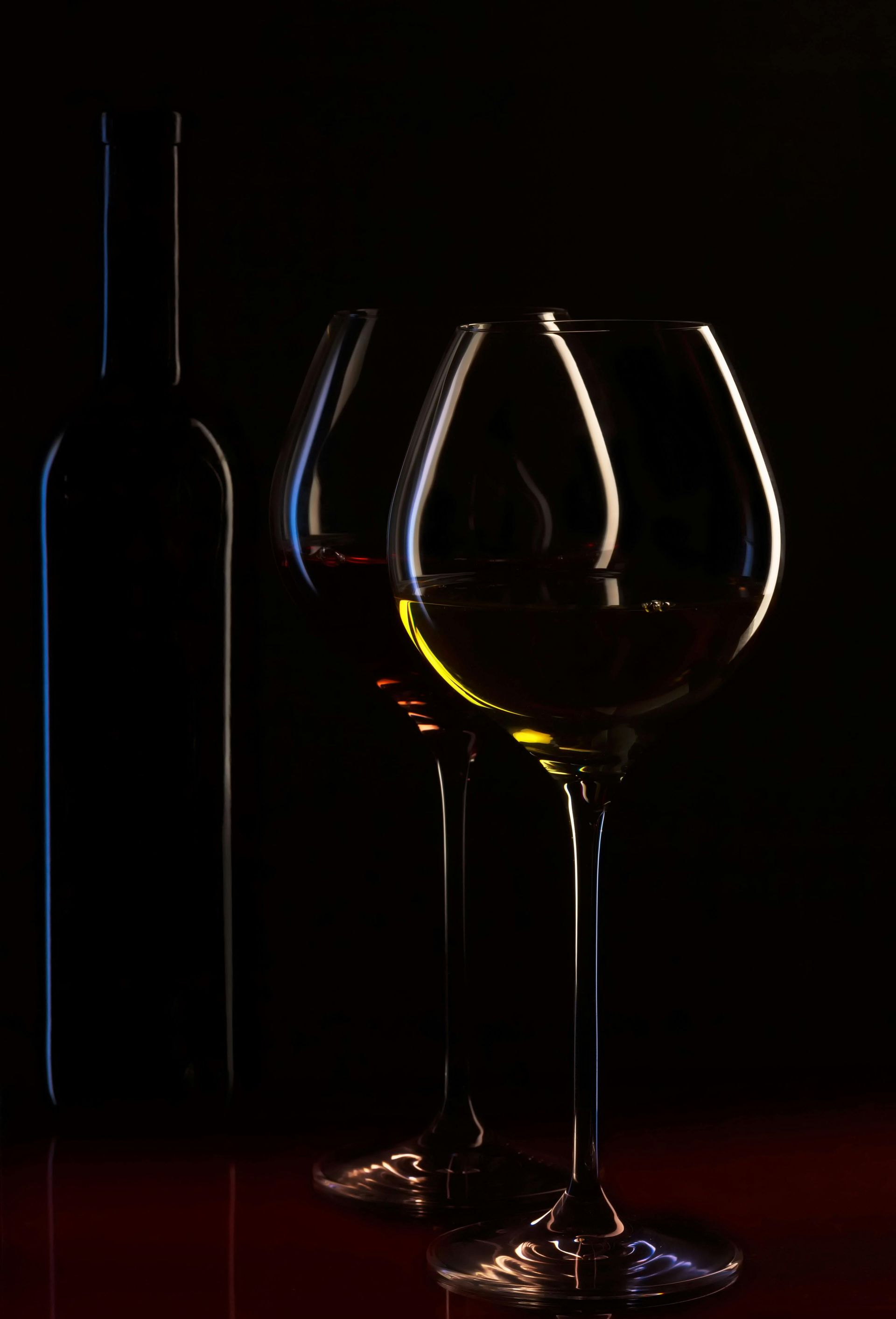 Un verre à vin est posé sur une table dans le noir.