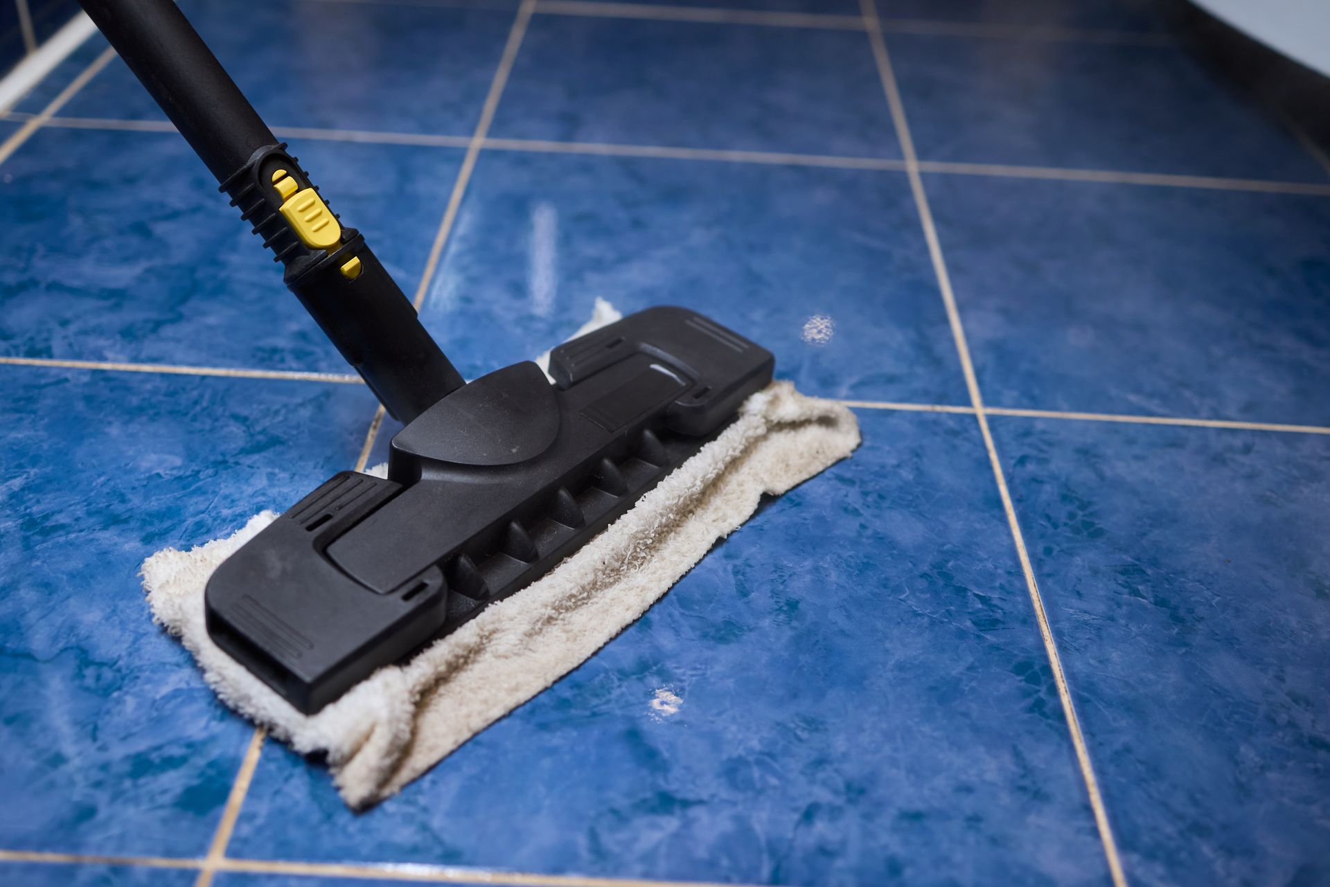 Mop head cleaning a blue tiled floor