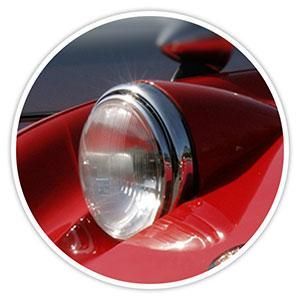 Close-up of a red classic car headlight with chrome trim