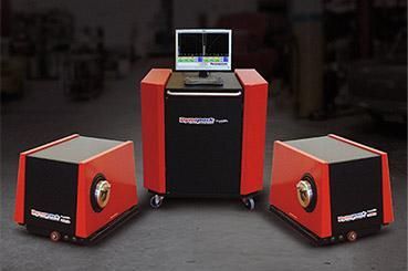 Three red and black wheeled robotic units, one with a laptop on top, displayed indoors.