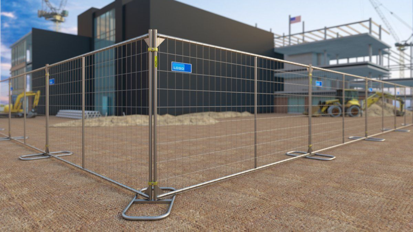 Construction site enclosed by a metal fence. Building under construction visible in the background.