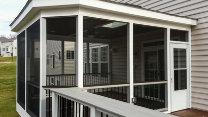 Screened porch with white trim, black screens, and deck with a view of a house and yard.