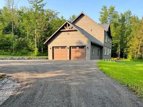 Une grande maison avec un garage et une allée devant.